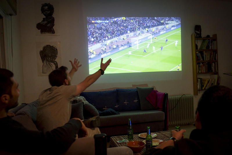 אוהדים צופים במשחק בביתם