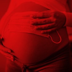 אישה בהריון עם מסיכה על הבטן