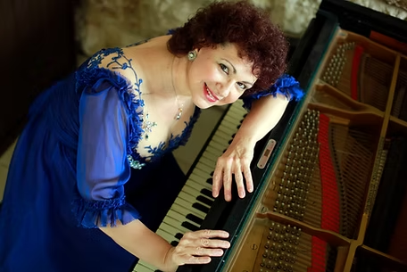 הפסנתרנית והחוקר אסתרית בלצן נשענת על פסנתר